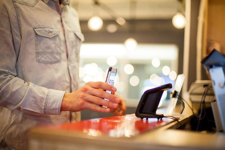 A worker using a touchscreen terminal at a service counter